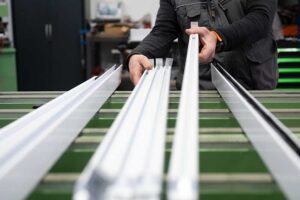 aluminum extrusion with several profiles in the main frame of the photo depicting manufacturing