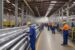 legacy of excellence - warehouse depicting a large volume of extruded aluminum with technicians wearing hardhats